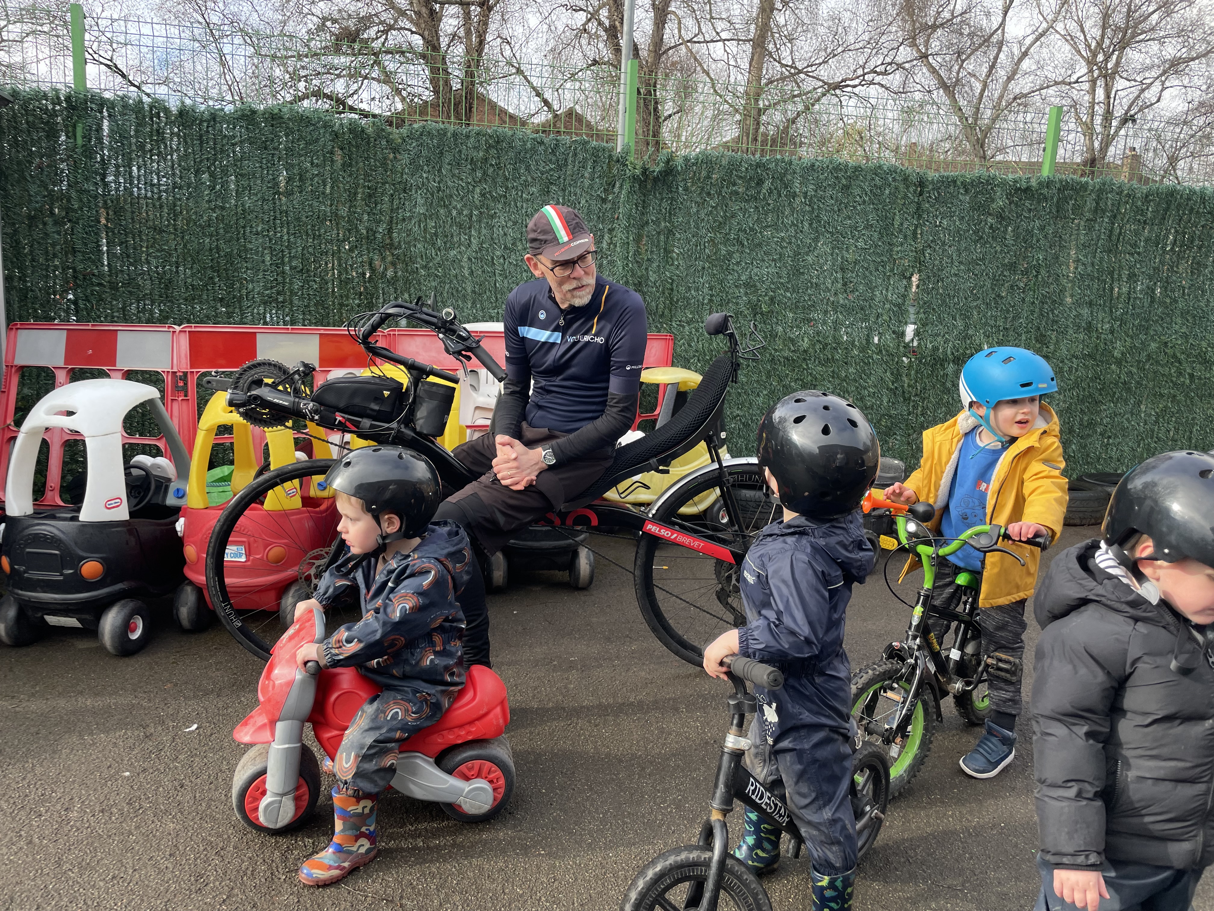 Man on recumbent bike talking to children